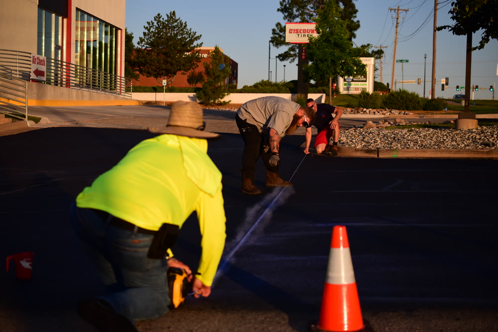 Trainee laying fresh parking lot lines at golden hour